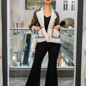 Step into timeless elegance with this black wide-leg pants and jacket set. The tailored jacket features a unique blend of textures with sheer mesh sleeves, soft tweed-like panels, and delicate fringe trim that adds a touch of edge. Designed with a relaxed open front, it layers effortlessly over the sleek wide-leg black pants for a sophisticated yet fashion-forward look. Perfect for evening events, work-to-dinner styling, or whenever you want to command attention with refined style. Color: Black with white jacket detail Details: Sheer mesh sleeves, fringe trim, open-front jacket, wide-leg pants Style: Modern | Sophisticated | Statement