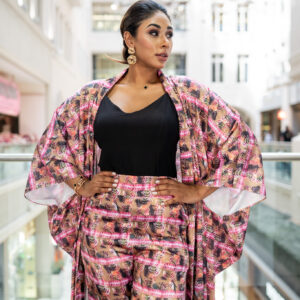 Zahara Luxe Printed Kimono Set Vibrant, fluid, and unapologetically chic, the Zahara Luxe kimono set captures the spirit of contemporary luxury with an exotic edge. Crafted from lightweight satin, it features a flowing full-length kimono and wide-leg trousers, both adorned with a captivating ethnic-inspired print in tones of rose, gold, and espresso. The relaxed silhouette drapes beautifully for movement and comfort, while the bold palette makes it perfect for both resort escapes and elevated city style. Wear it open over a simple camisole or cinch the waist for added definition.