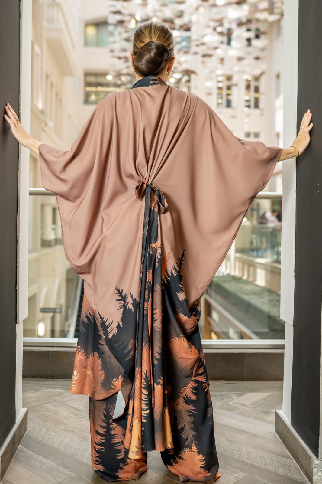 Desert Nocturne This two-piece ensemble features a structured button-down tunic with a softly sculpted mandarin collar and gold-tone statement buttons, flowing into a dramatic cape silhouette sleeve. The back reveals an exquisite gathered drape detail with a tie accent, creating movement and architectural depth from every angle - Image 4