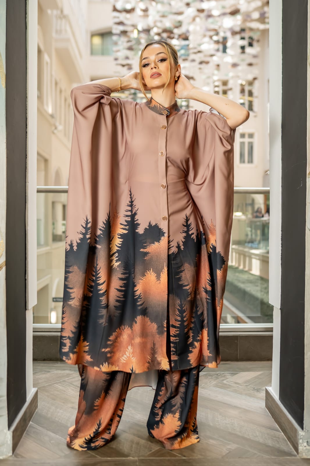 Desert Nocturne This two-piece ensemble features a structured button-down tunic with a softly sculpted mandarin collar and gold-tone statement buttons, flowing into a dramatic cape silhouette sleeve. The back reveals an exquisite gathered drape detail with a tie accent, creating movement and architectural depth from every angle - Image 2